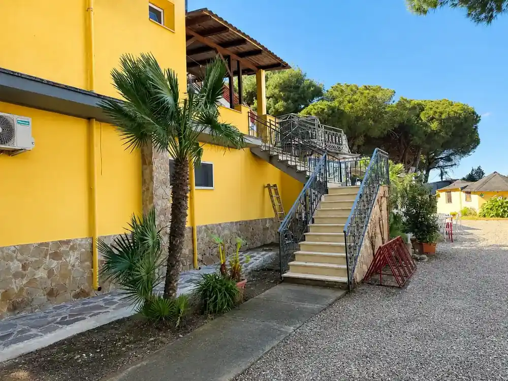 Lato soleggiato dell'Hotel Paradiso con palme e scale esterne